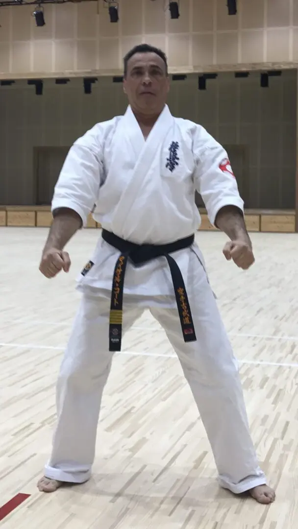 A man in white and black uniform standing on a court.